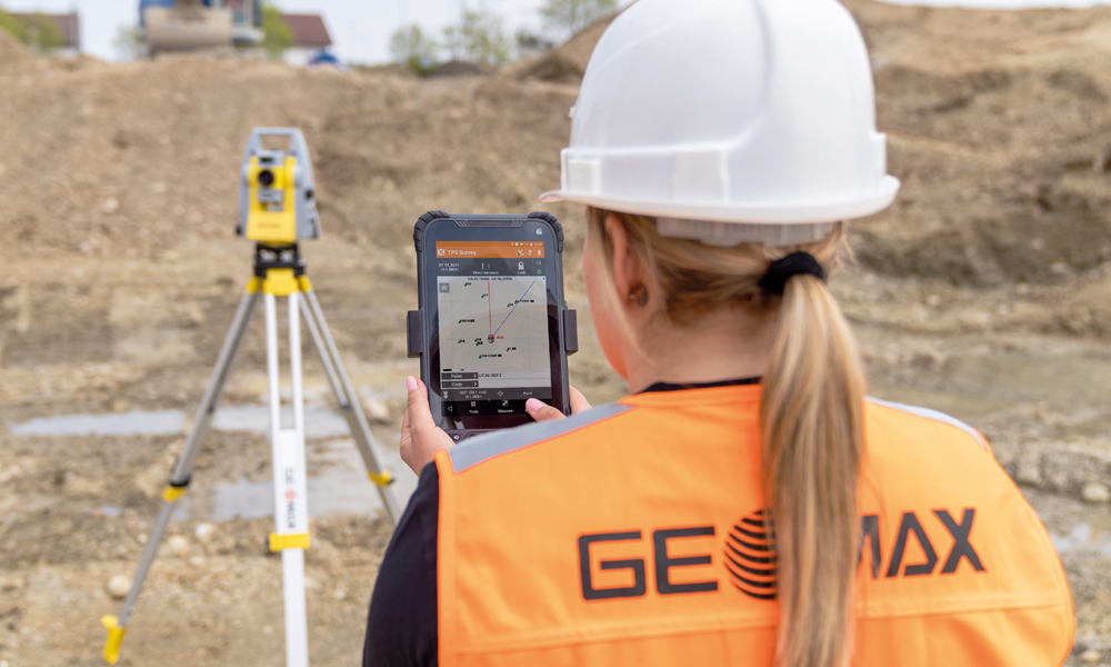 surveyor using geomax zenius800 android tablet running x-pad software and working with the geomax zoom95 robotic total station out on a construction site